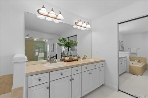 a spacious en suite bathroom with double sink and a mirror