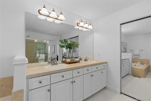 a spacious en suite bathroom with double sink and a mirror