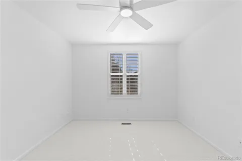 an empty room with a window and a fan