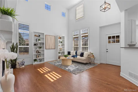 a living room with furniture wooden floor and a large window