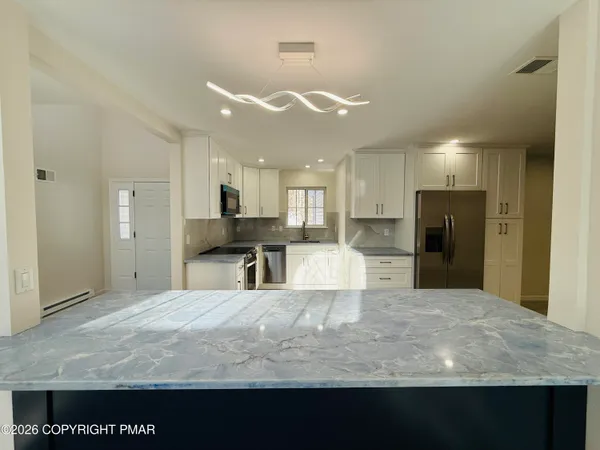 a view of kitchen with refrigerator stove and a sink