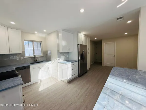 a kitchen with stainless steel appliances granite countertop a refrigerator and a stove top oven