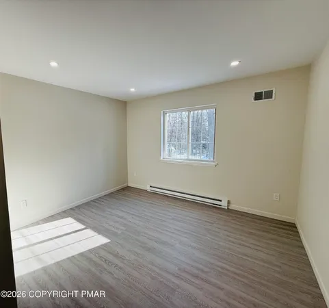 a view of an empty room with wooden floor