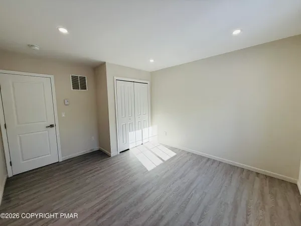 an empty room with wooden floor and sliding door