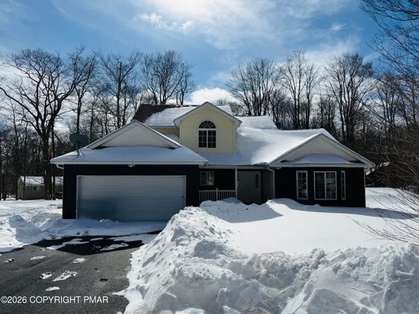 a front view of a house with a yard covered with snow in front of house