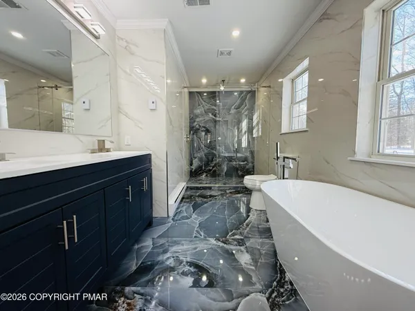 a spacious bathroom with a bathtub sink and mirror