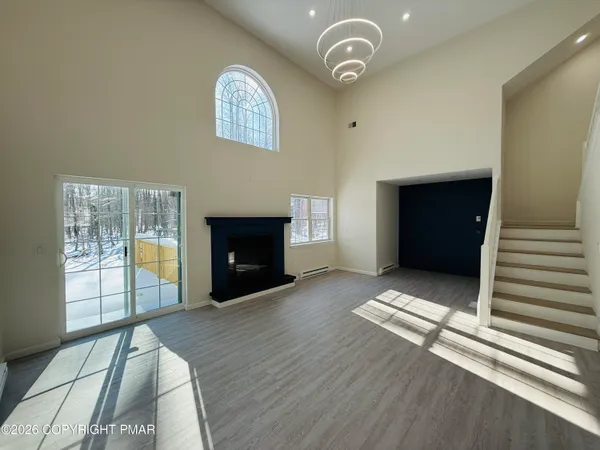 an empty room with windows and fireplace