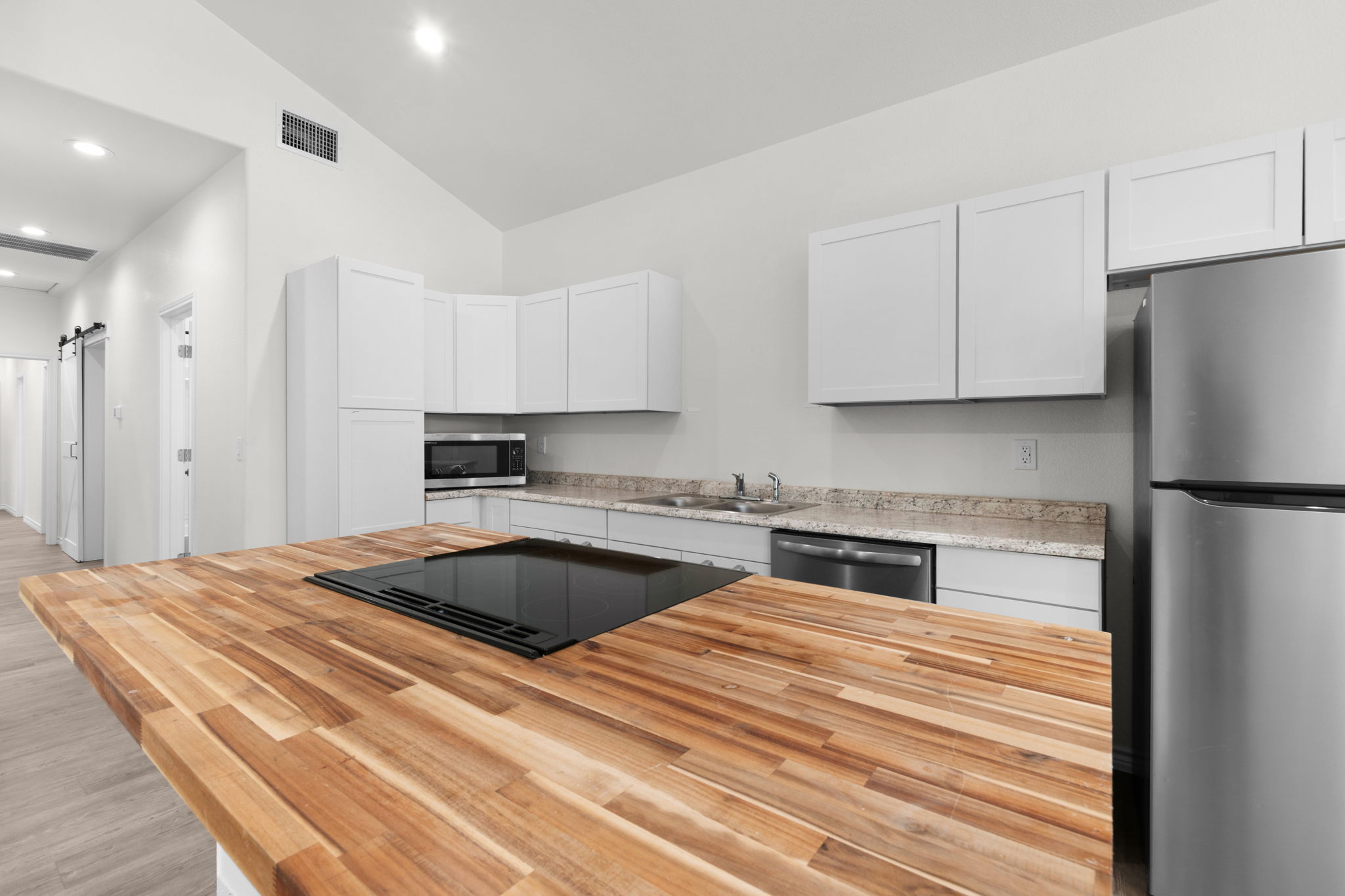 870 Waco Street Kingsland, TX 78639 - Photo 7 of 30 a kitchen with granite countertop a refrigerator sink and cabinets