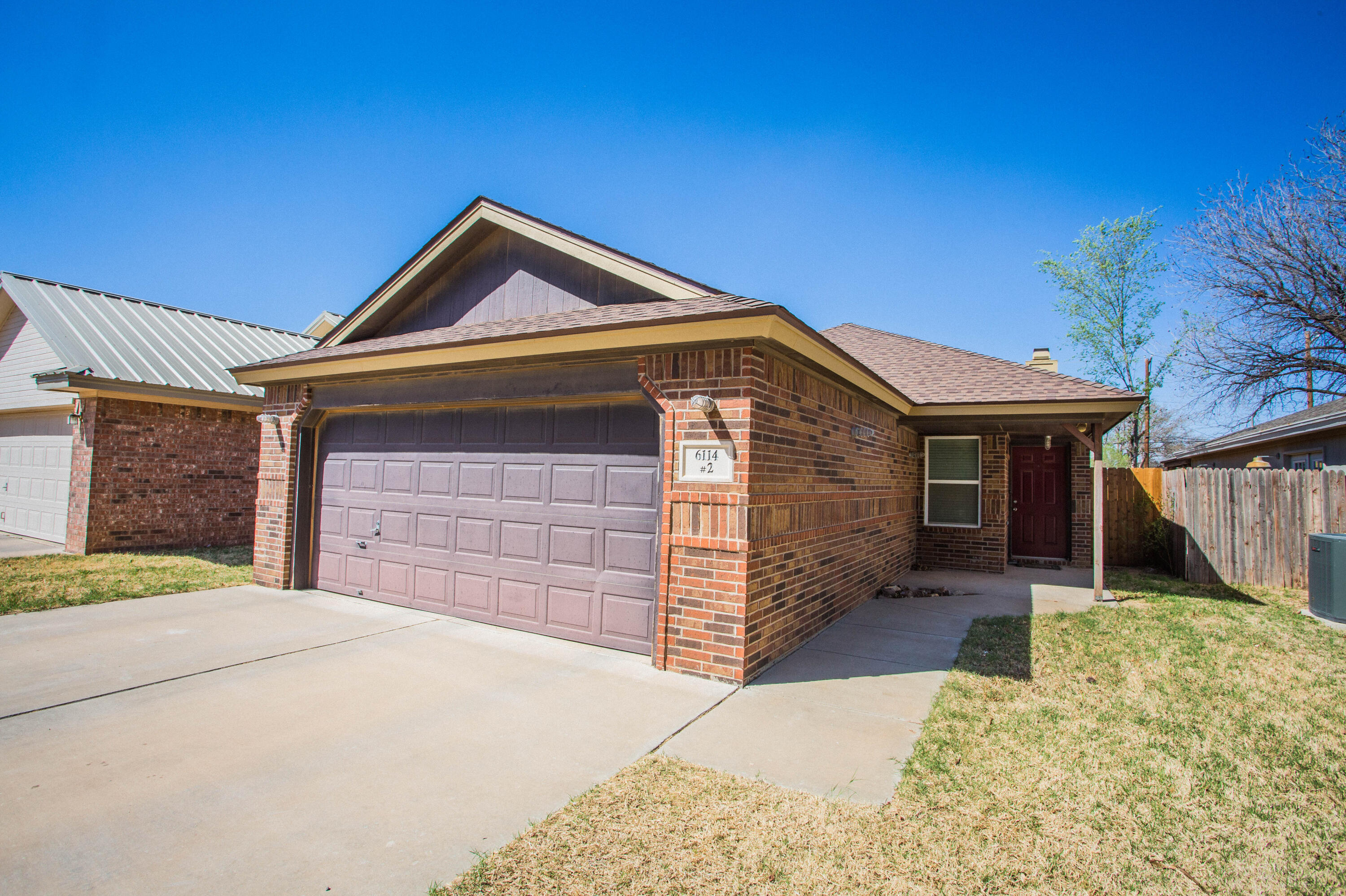 6114 22nd Street, Unit 2 Lubbock, TX 79407 - Photo 1 of 48 a front view of a house with a yard and garage