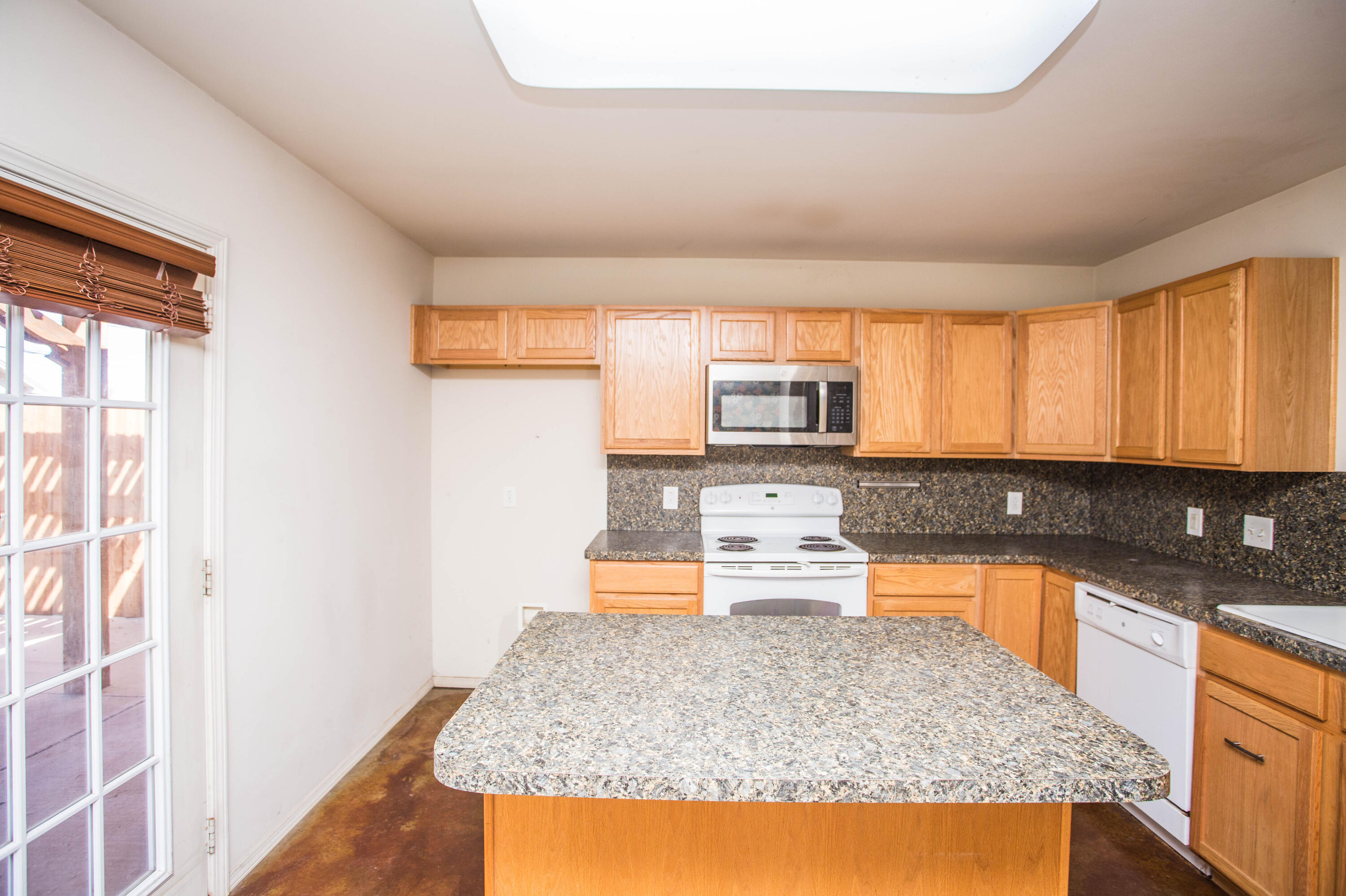6114 22nd Street, Unit 2 Lubbock, TX 79407 - Photo 12 of 48 a kitchen with stainless steel appliances granite countertop a sink stove and cabinets