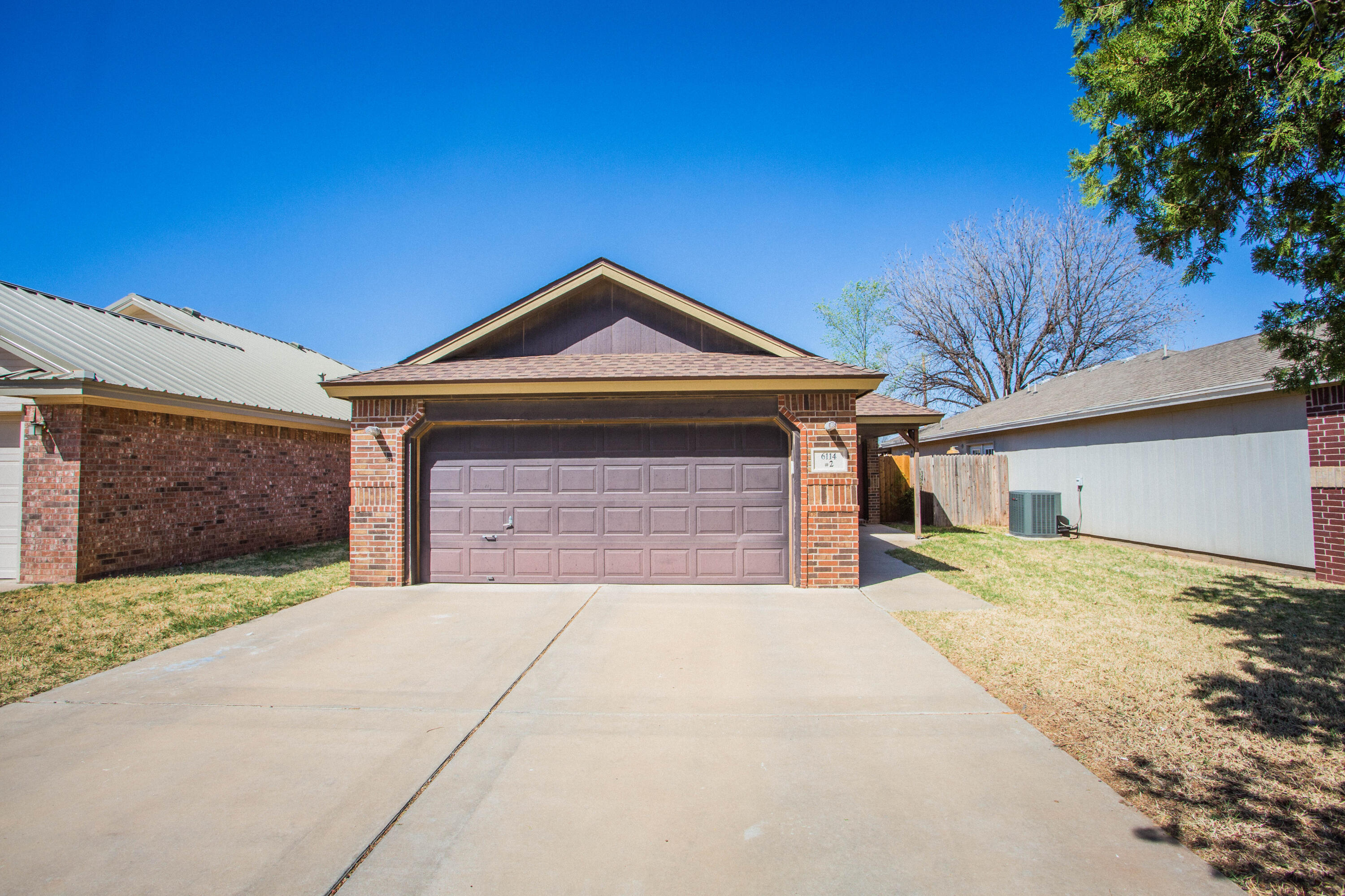 6114 22nd Street, Unit 2 Lubbock, TX 79407 - Photo 2 of 48 a front view of a house with a yard and garage