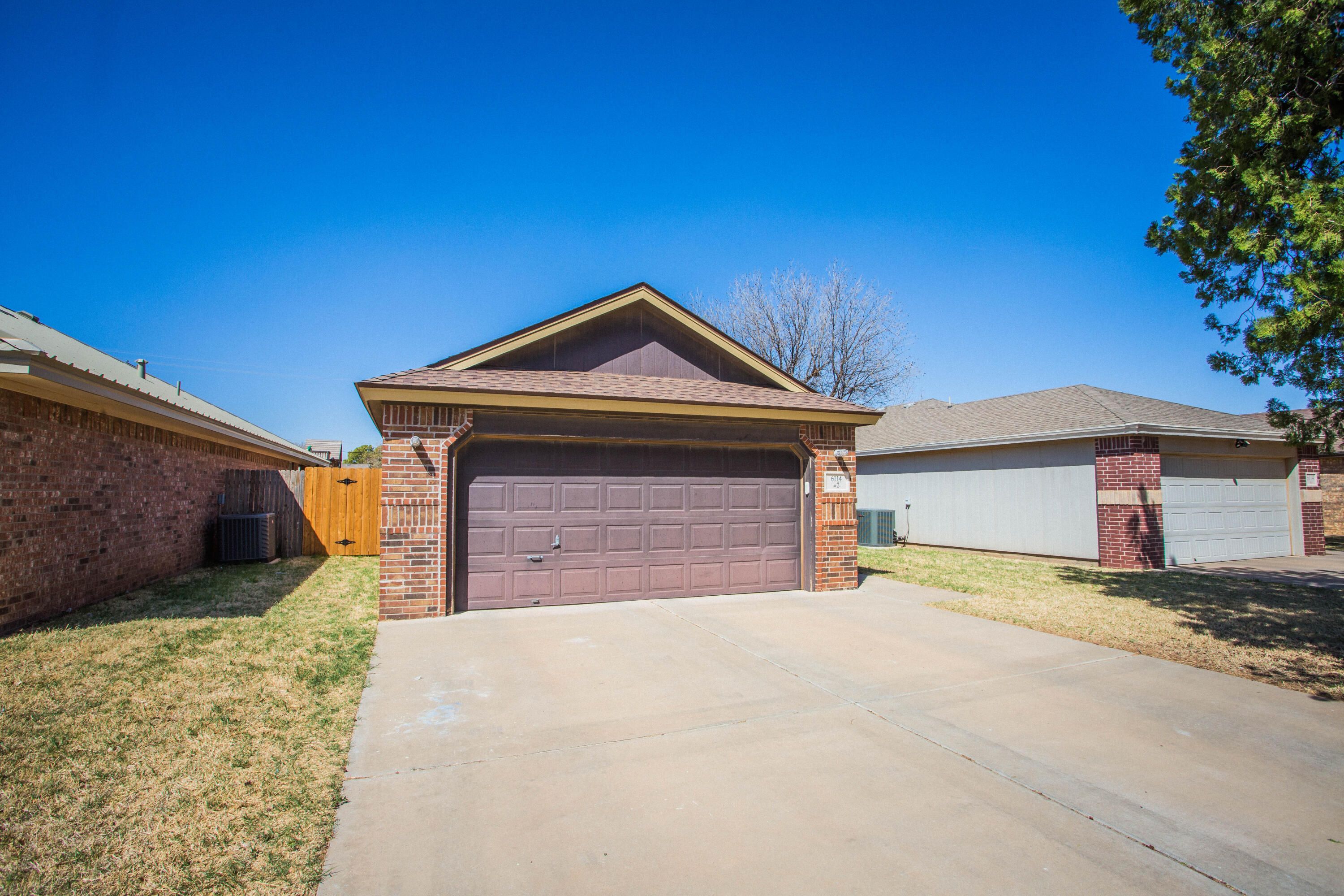 6114 22nd Street, Unit 2 Lubbock, TX 79407 - Photo 4 of 48 a front view of a house with a yard and garage
