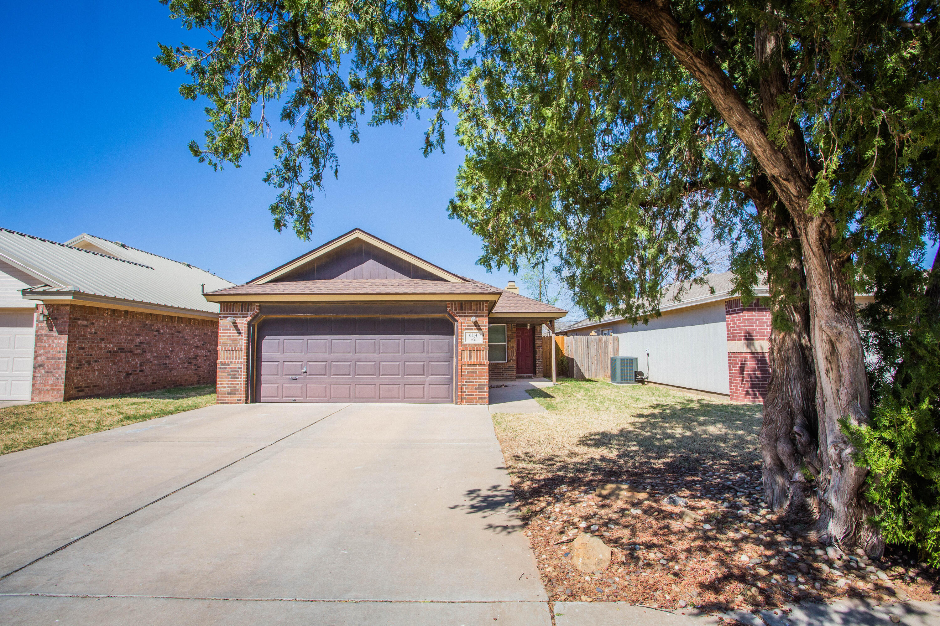 6114 22nd Street, Unit 2 Lubbock, TX 79407 - Photo 5 of 48 a front view of a house with a yard and garage