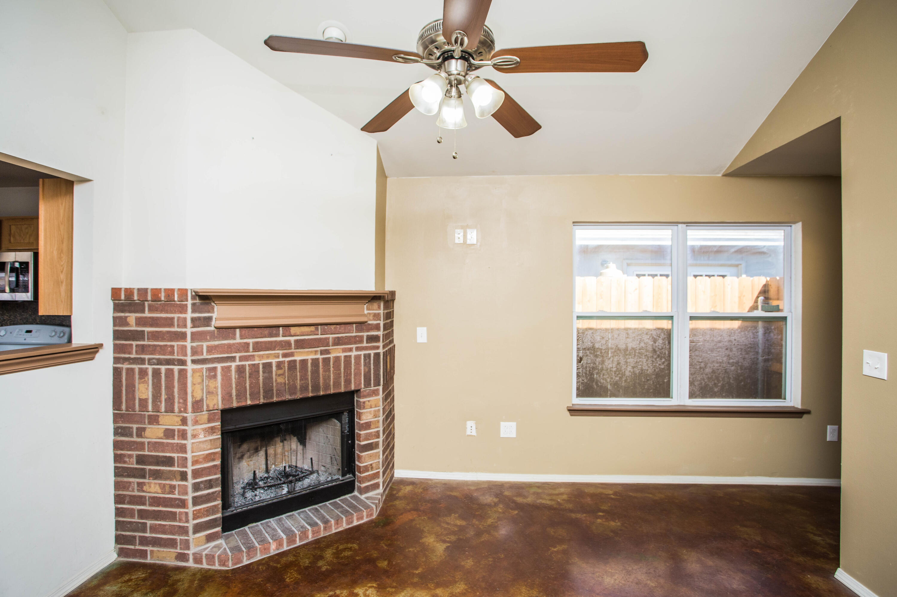 6114 22nd Street, Unit 2 Lubbock, TX 79407 - Photo 10 of 48 a living room with a fireplace and a ceiling fan