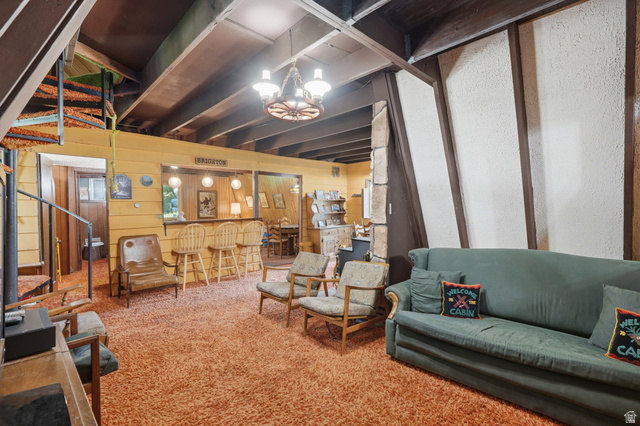 8505 South Snake Crk Road Salt Lake City, UT 84121 - Photo 7 of 67 Recreational space featuring a built-in bar with seating, exposed ceiling beams, a spiral staircase, textured wall panels, and a wagon wheel chandelier