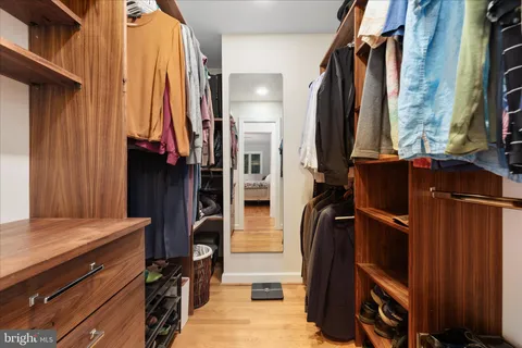 a view of walk in closet with clothes and shoes