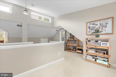 a living room with furniture and a baby crib