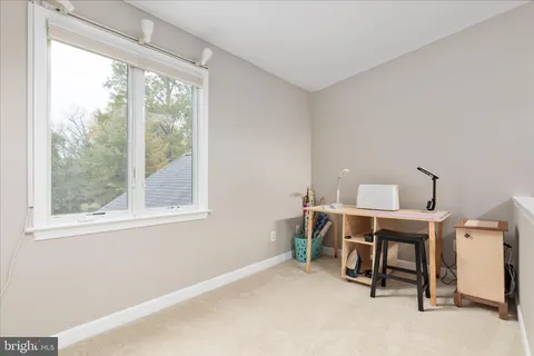 a view of a workspace with furniture and a window