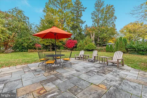 a view of backyard with furniture and umbrella