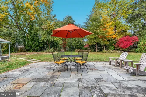 a view of a house with backyard and sitting area