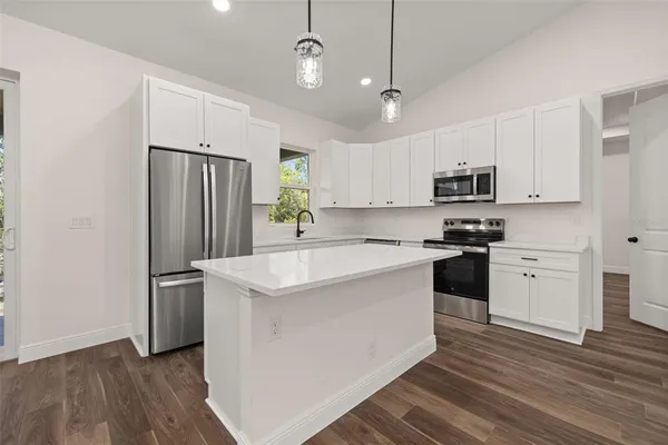 a kitchen with stainless steel appliances a refrigerator sink and microwave