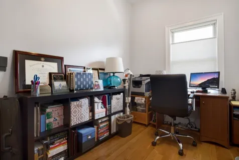 a view of a workspace with furniture and a window