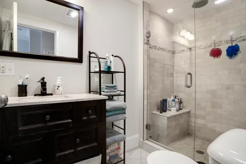a bathroom with a sink a toilet and shower