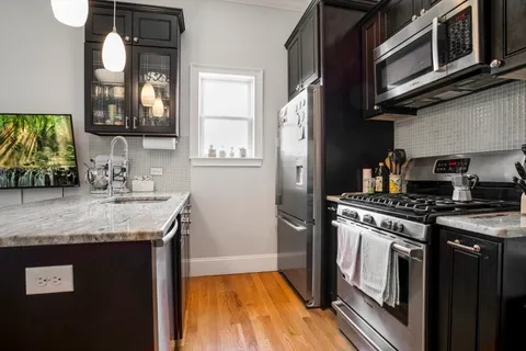 a kitchen with stainless steel appliances granite countertop a stove a sink and a microwave