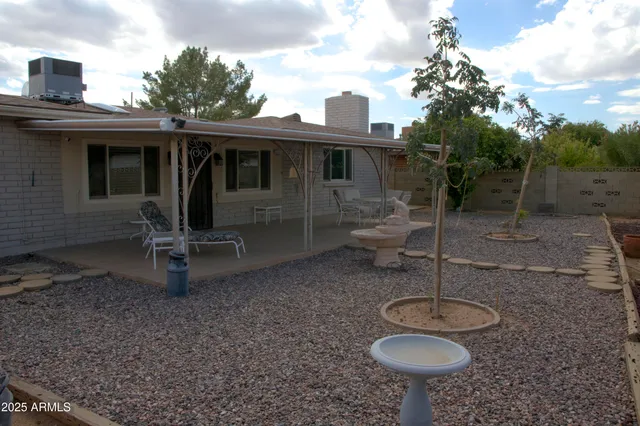 a view of patio with table and chairs under an umbrella with a barbeque