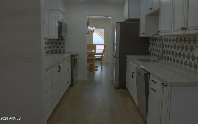 a kitchen with cabinets and chairs