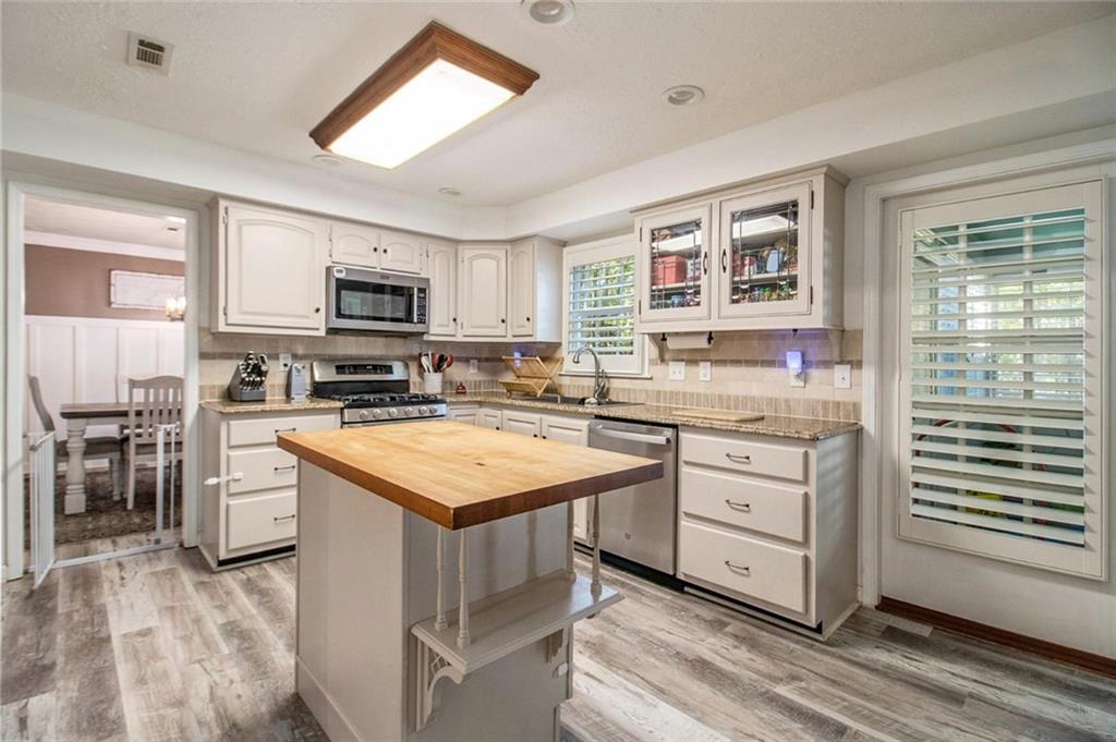 160 Old Field Road Sharpsburg, GA 30277 - Photo 22 of 58 a kitchen with stainless steel appliances granite countertop a stove top oven a sink dishwasher and a refrigerator