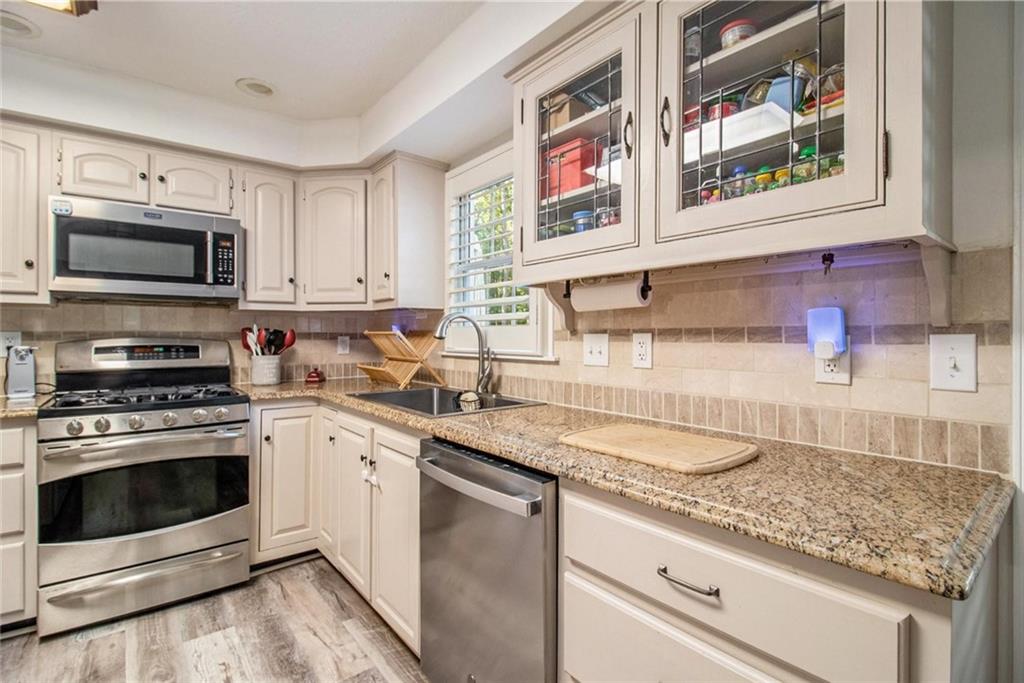 160 Old Field Road Sharpsburg, GA 30277 - Photo 23 of 58 a kitchen with granite countertop stainless steel appliances a stove sink and microwave