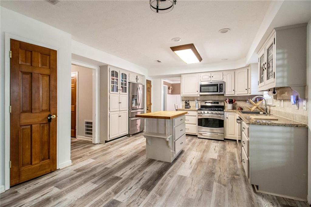160 Old Field Road Sharpsburg, GA 30277 - Photo 25 of 58 a kitchen with a refrigerator cabinets and wooden floor