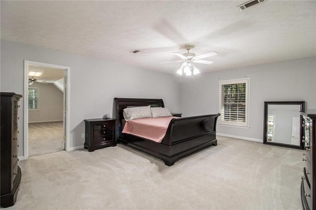 160 Old Field Road Sharpsburg, GA 30277 - Photo 28 of 58 a bedroom with a bed and a chandelier