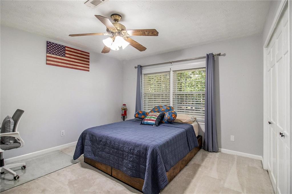 160 Old Field Road Sharpsburg, GA 30277 - Photo 33 of 58 a bedroom with a bed and a chandelier