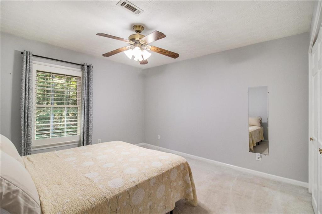 160 Old Field Road Sharpsburg, GA 30277 - Photo 34 of 58 a bedroom with a large bed and a chandelier