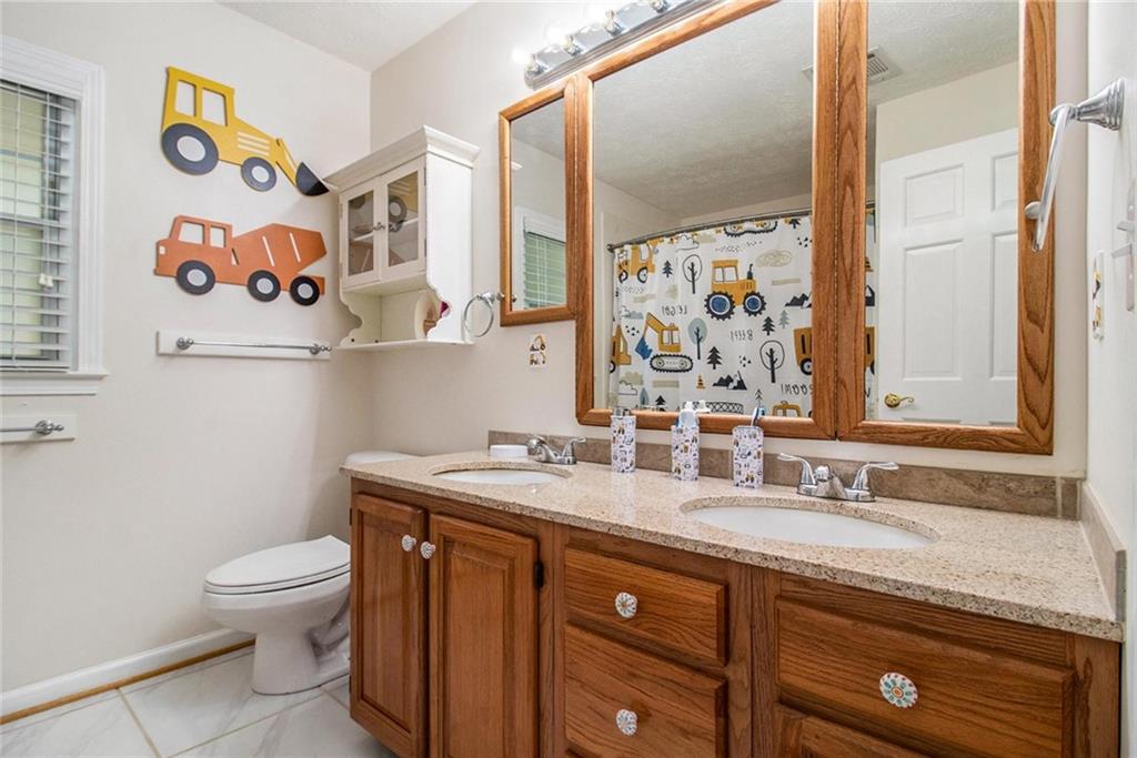 160 Old Field Road Sharpsburg, GA 30277 - Photo 36 of 58 a bathroom with a granite countertop sink a toilet and a mirror