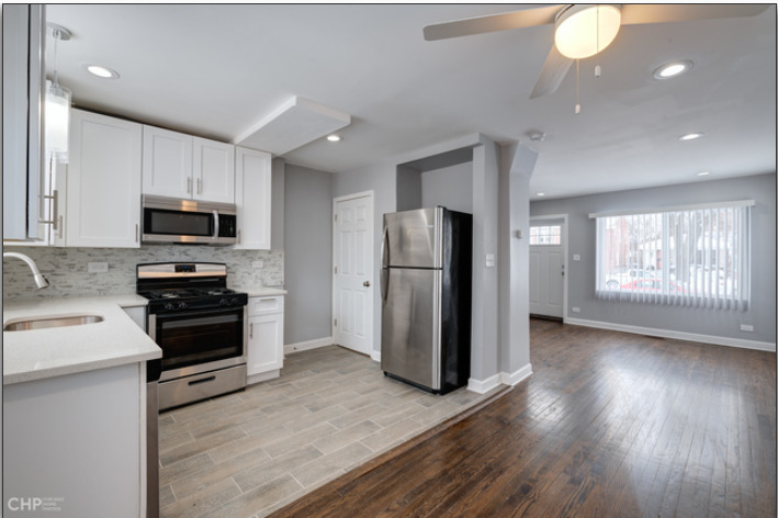 654 East 105th Street Chicago, IL 60628 - Photo 6 of 12 a kitchen with a refrigerator and a stove top oven