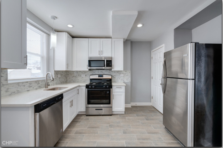 654 East 105th Street Chicago, IL 60628 - Photo 7 of 12 a kitchen with stainless steel appliances a refrigerator sink and microwave