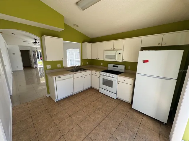 a kitchen with a sink a refrigerator a microwave and cabinets