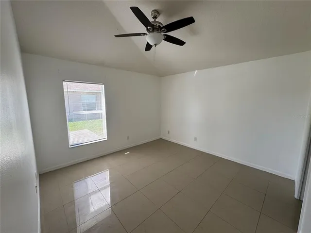 an empty room with a window and a fan