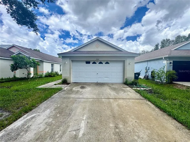 a front view of a house with a yard and a garage