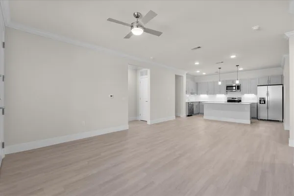 a kitchen with a refrigerator a sink and wooden floor