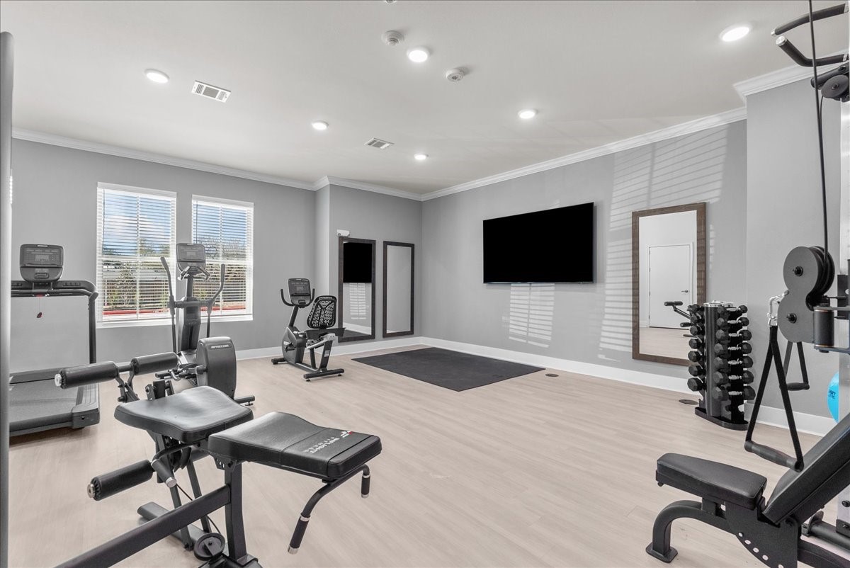 540 Hobbs Road, Unit E1 League City, TX 77573 - Photo 21 of 40 a room with gym equipment and a flat screen tv