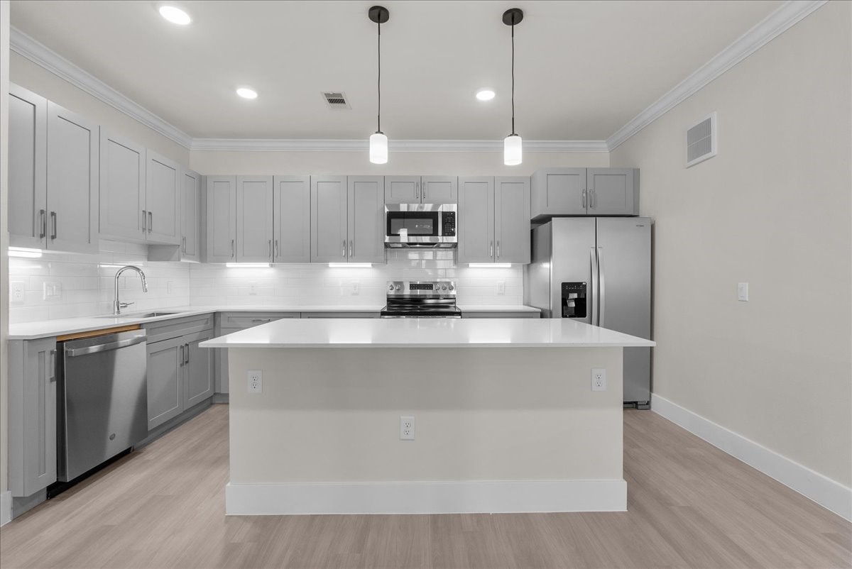 540 Hobbs Road, Unit E1 League City, TX 77573 - Photo 5 of 40 a kitchen with a refrigerator a sink and wooden floor