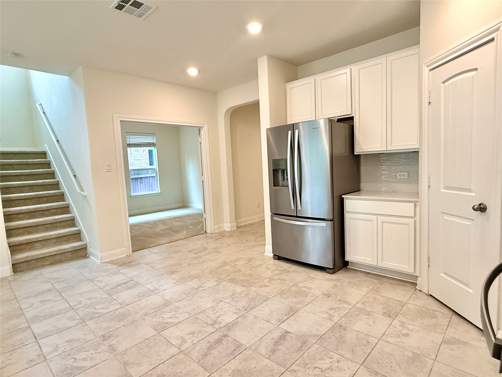 2101 Split Diamond Way, Unit 40 Round Rock, TX 78664 - Photo 6 of 32 A well-lit interior features a modern kitchen and a carpeted staircase leading to upper levels.