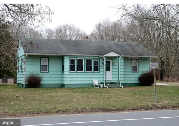 a view of a house with a yard and large tree