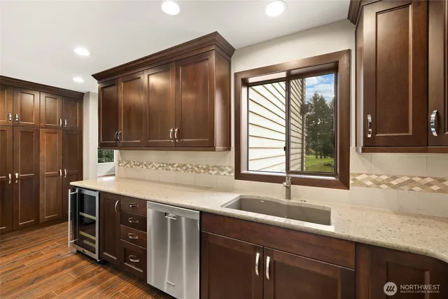 a kitchen with stainless steel appliances granite countertop a sink and a large window