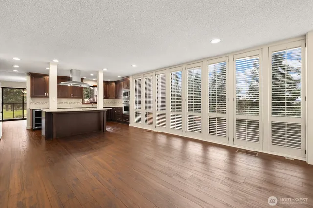 a view of a big room with wooden floor and windows