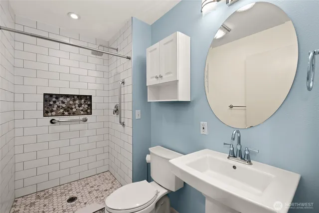 a bathroom with a sink a toilet and shower